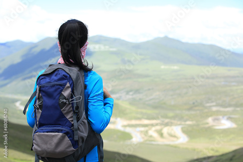 hiking woman enjoy the beautiful view at mountain peak in tibet 