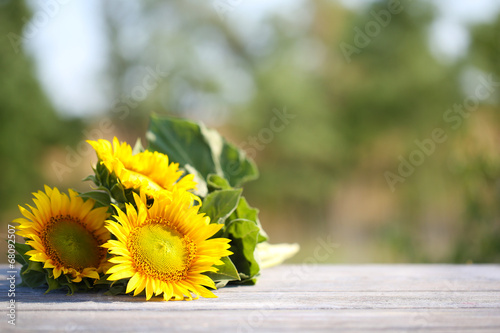 Fototapeta Naklejka Na Ścianę i Meble -  Beautiful sunflowers on table on bright background