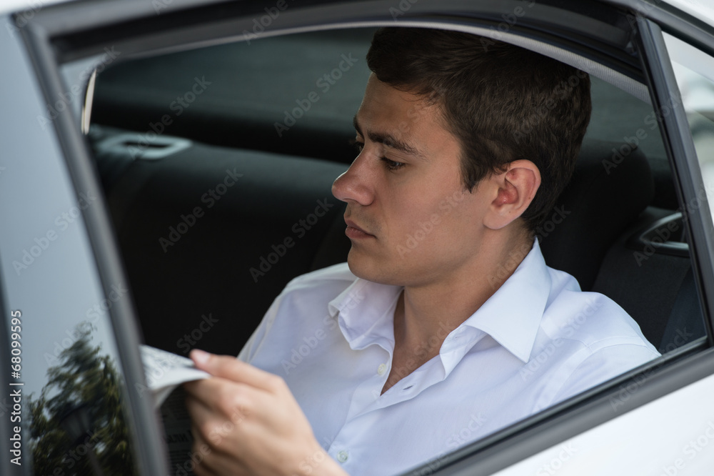 Businessman car reading newspaper