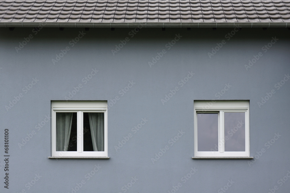 Graue Fassade eines modernen Wohnhauses mit zwei Fenstern