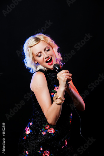 Photography Beautiful singing woman with microphone. Singer. Karaoke song