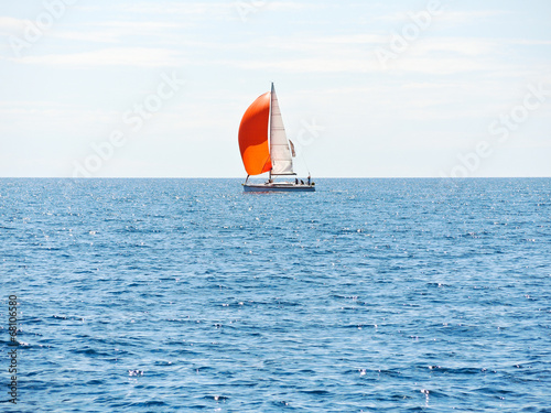 yacht with red sail in blue Adriatic sea