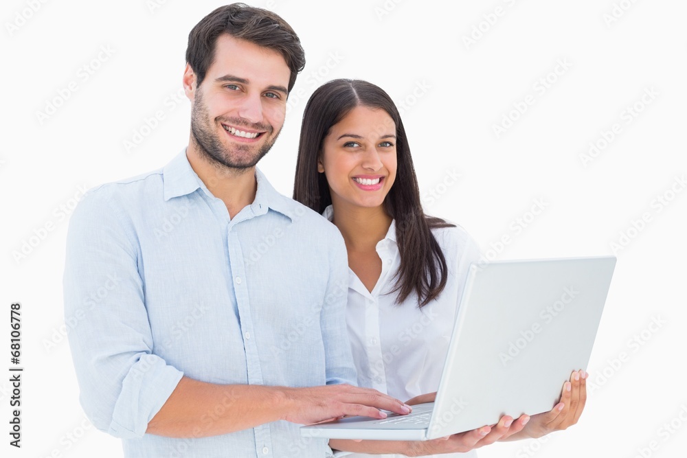 Attractive young couple holding their laptop Attractive young couple holding their laptop