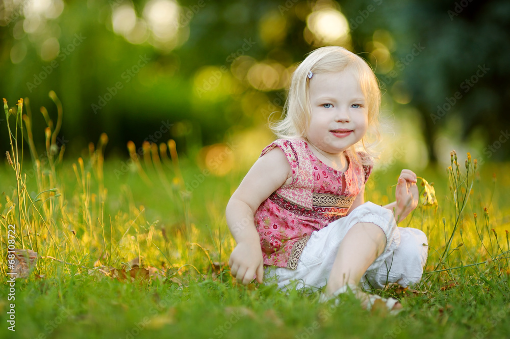 Cute little toddler girl sitting on the grass Cute little toddler girl sitting on the grass