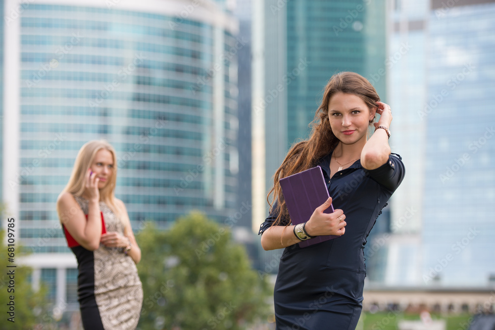 Fototapeta premium Two young businesswoman near skyscrapers