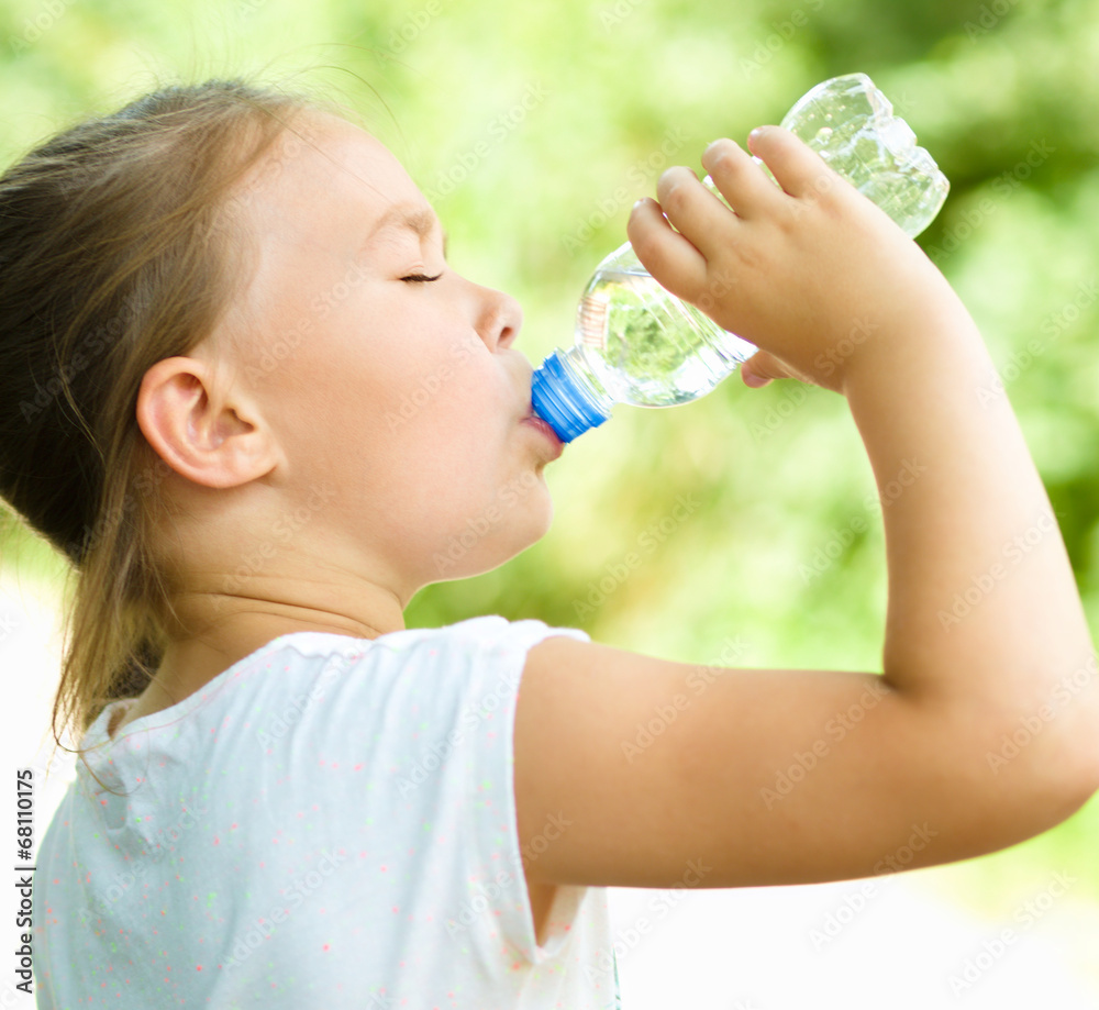 Cute girl drinks water from a plastic bottle Cute girl drinks water from a plastic bottle