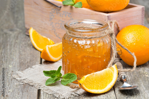 orange marmalade in a glass jar, horizontal photo
