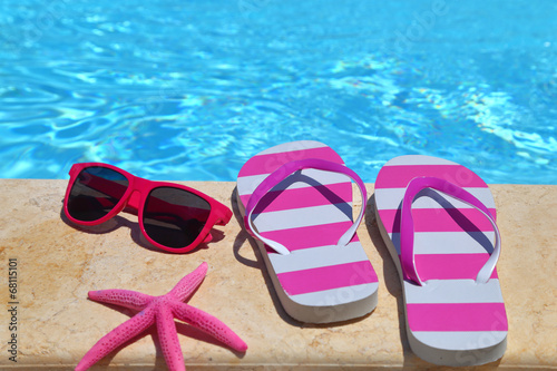 Flip flops, glasses and starfish by the poolside