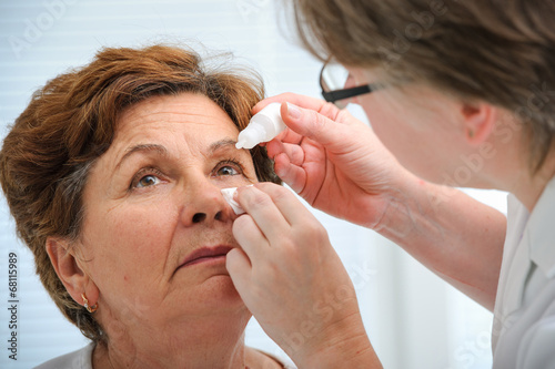 Senior woman applying eye drops