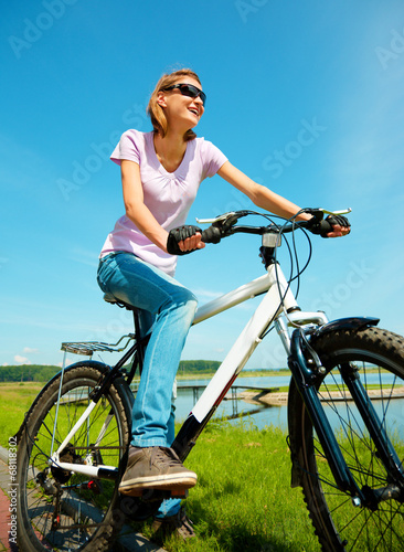 Young woman is sitting on her bicycle