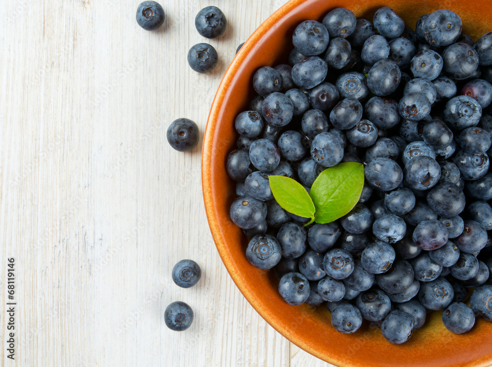 fresh blueberries in a bowl on wooden surface fresh blueberries in a bowl on wooden surface