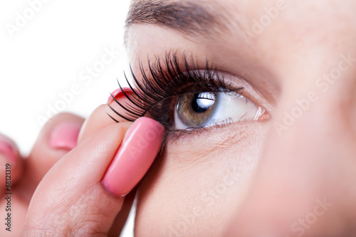 Foto Woman applying false eyelashes