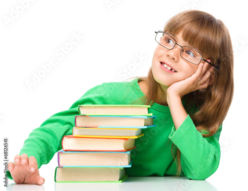 Young girl is daydreaming while reading book