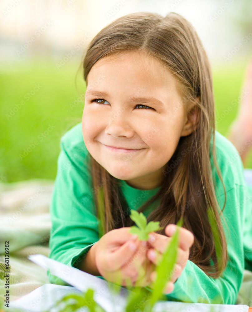 Portrait of a little girl laying on green grass Portrait of a little girl laying on green grass