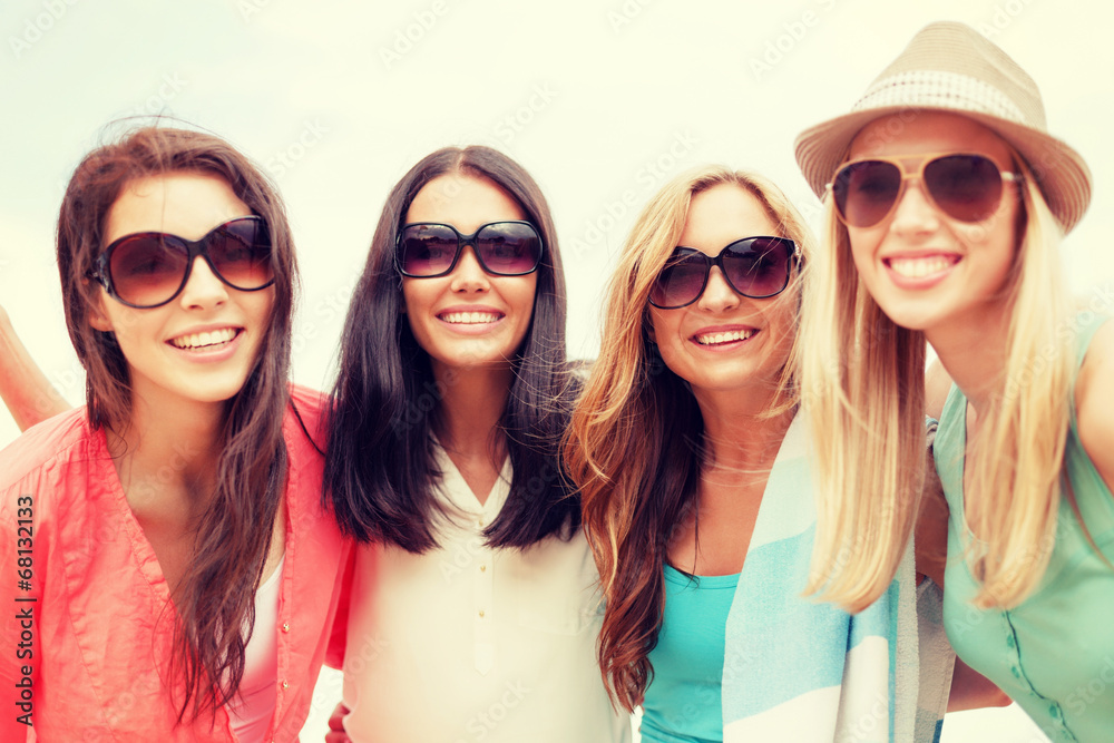 girls in shades having fun on the beach