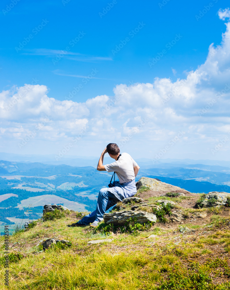 Man sitting and looking at mountains