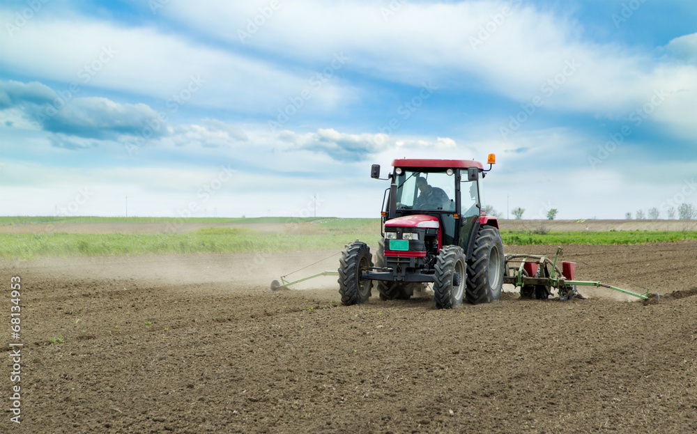 Young farmer sowing crops at field with pneumatic sowing machine Young farmer sowing crops at field with pneumatic sowing machine