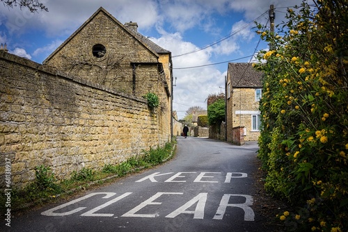 Keep Clear road sign with old lady. Cotswolds