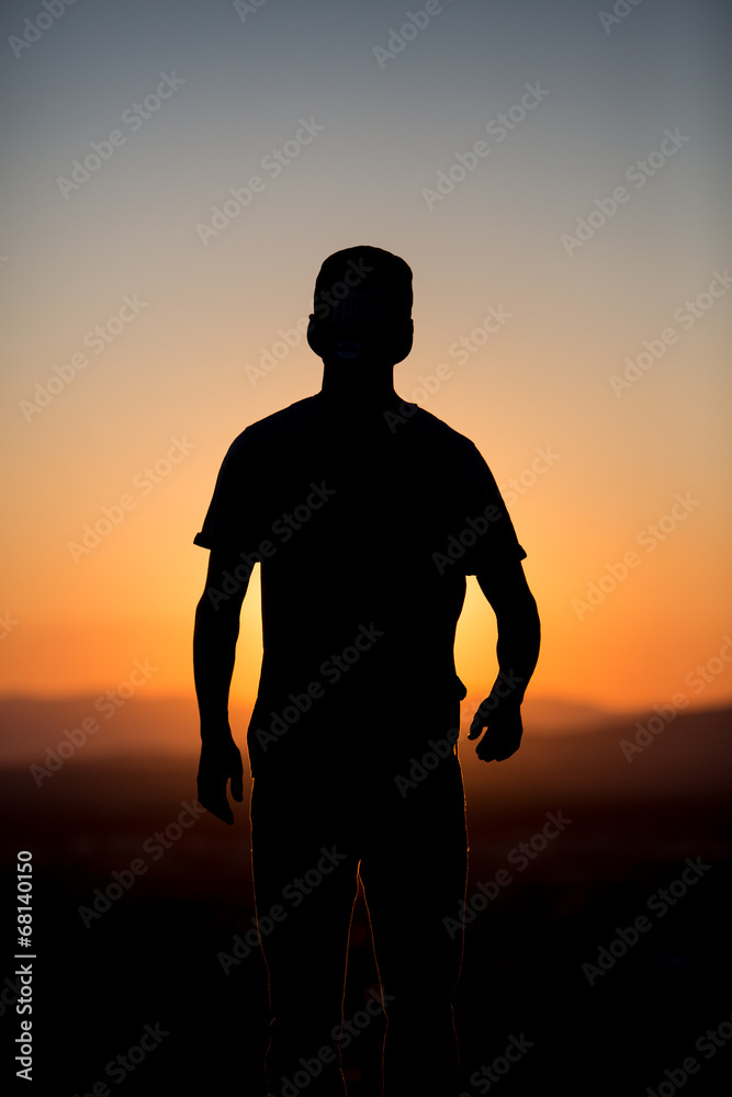 silhouetted male youth in sunset