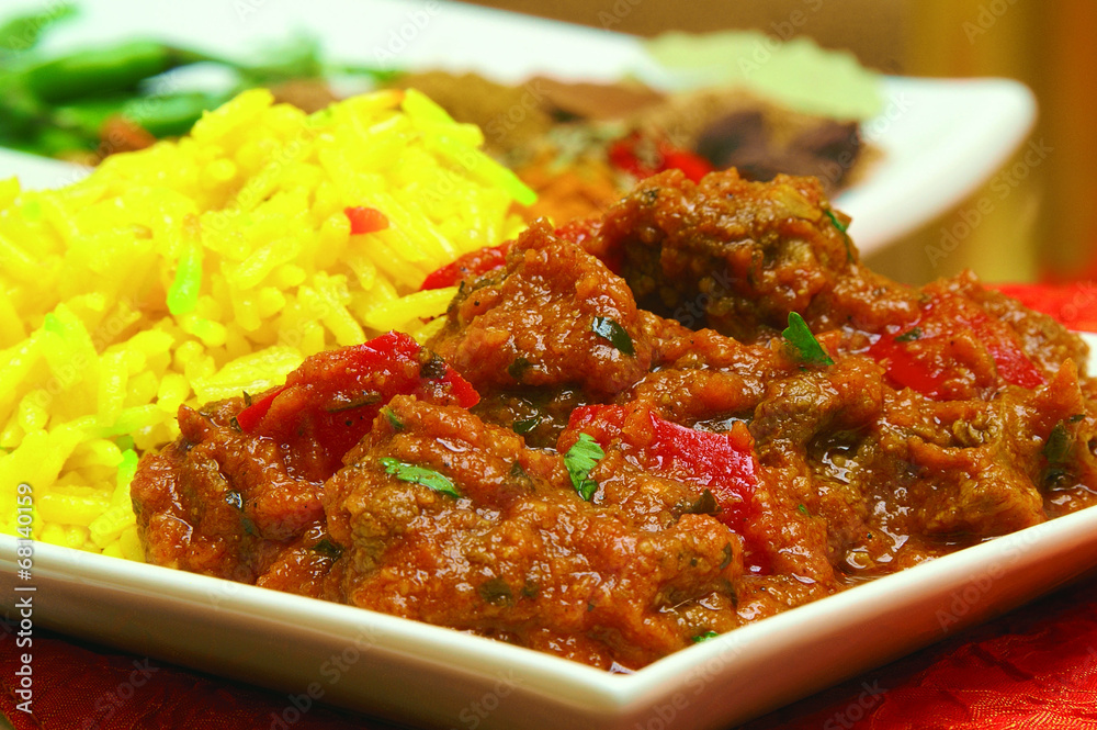 traditional indian curry in dish with pilau rice traditional indian curry in dish with pilau rice