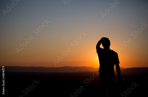 silhouetted male youth in sunset