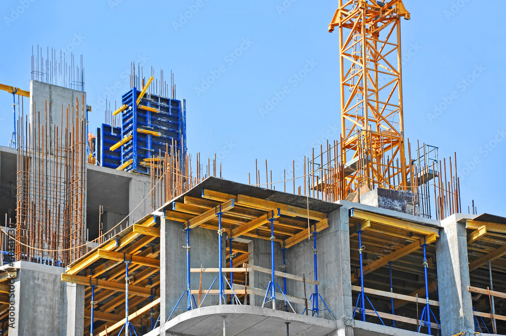 Crane and building construction site against blue sky - obrazy, fototapety, plakaty 