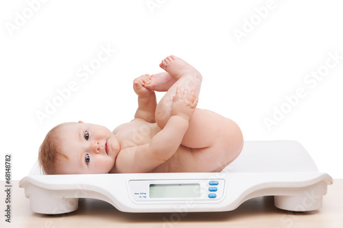 portrait of baby boy lying on scales.