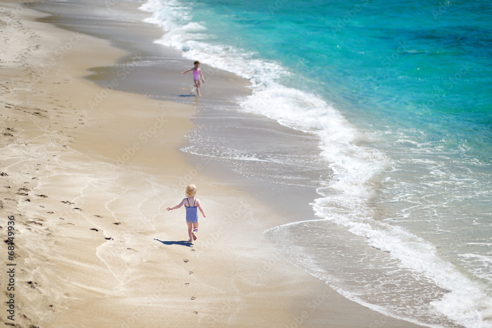 Two little sisters having fun on a beach Two little sisters having fun on a beach