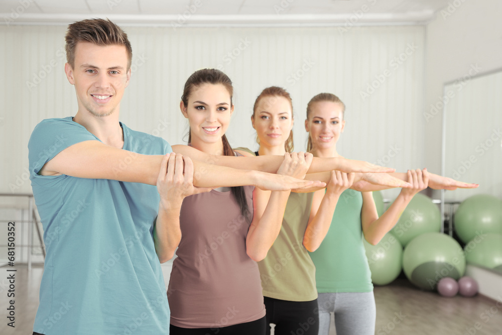 Fototapeta premium Young people exercising at gym