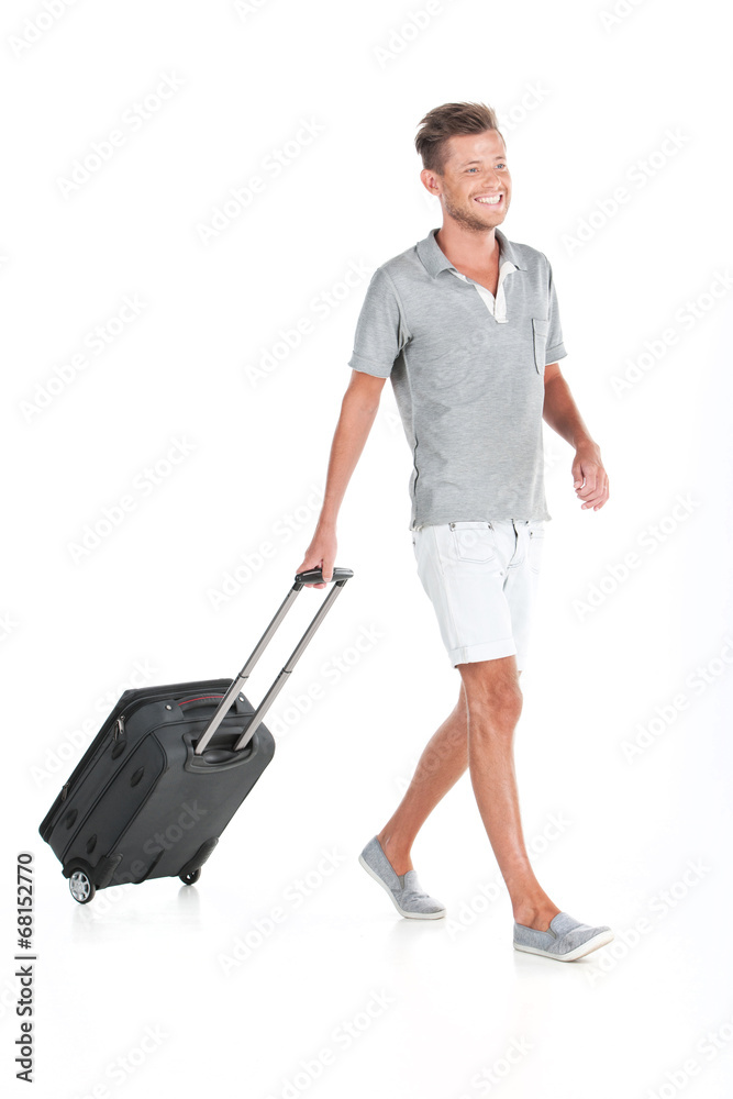 handsome guy walking with luggage and smiling. handsome guy walking with luggage and smiling.