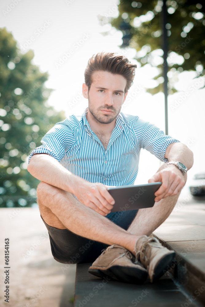 Obraz premium young handsome hipster modern man using tablet outdoor