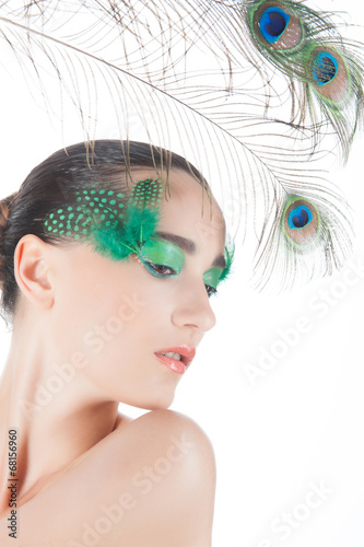 Beautiful brunette young woman with peacock style make-up and pe