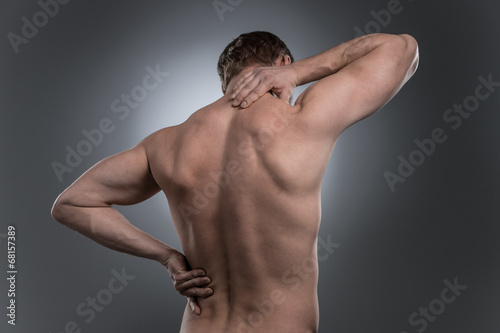 Quadro su tela back view of young shirtless man with neck pain.