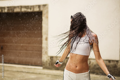 A happy young woman enjoying rain