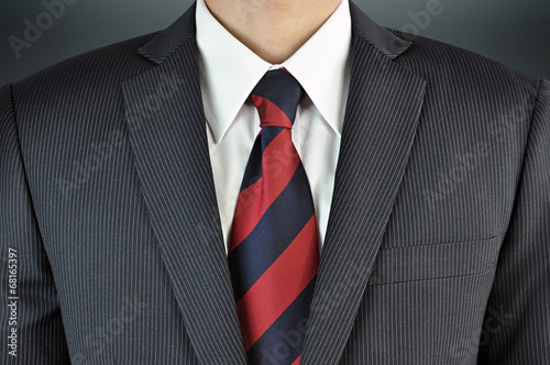 Obraz na plátně A man wearing suit with stripe necktie - business attire