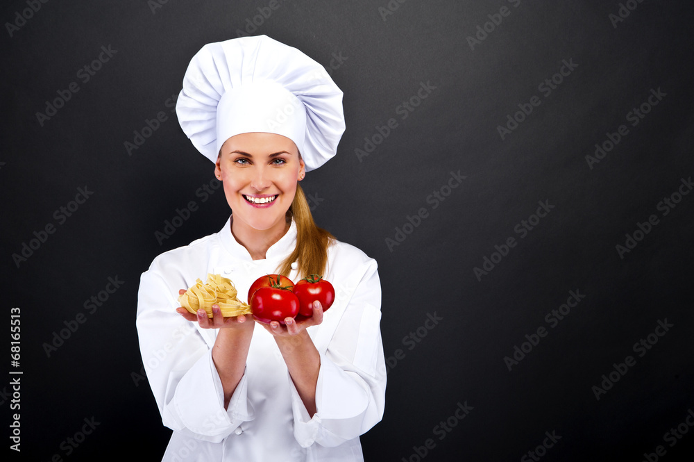 woman chef over dark background with tomatos and pasta noodles woman chef over dark background with tomatos and pasta noodles