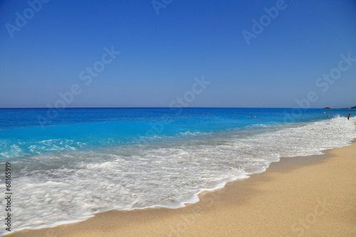 Sandy seashore with blue sky and water