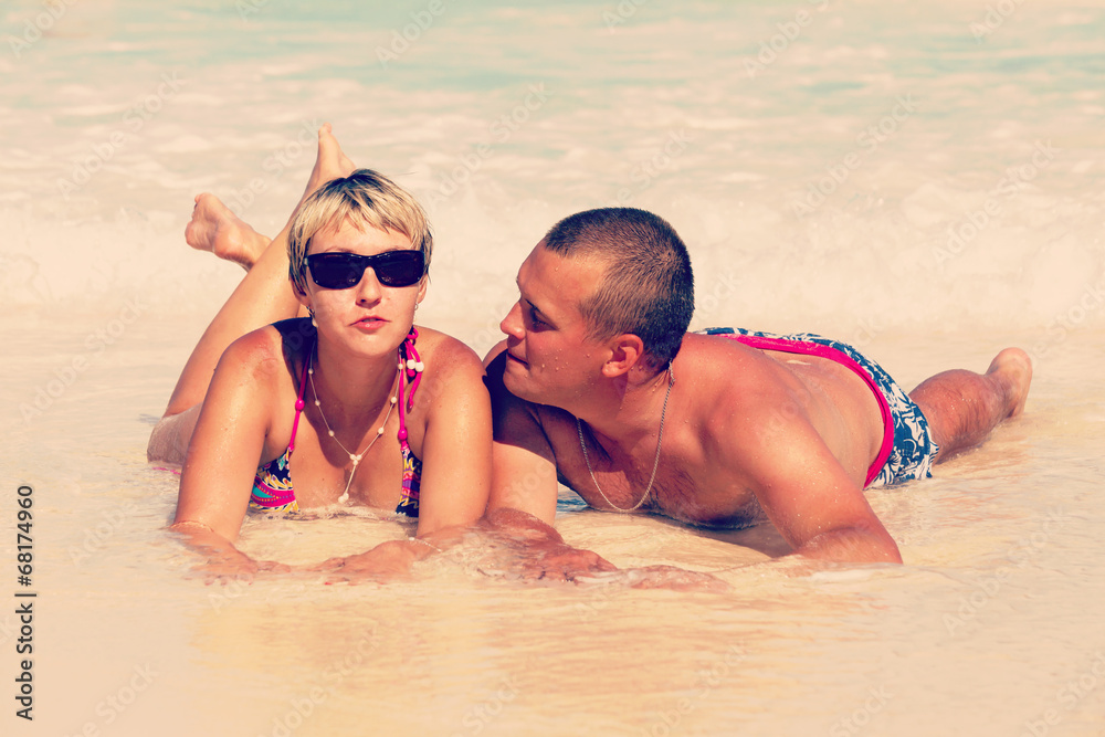 Young romantic couple laying on sandy beach Young romantic couple laying on sandy beach