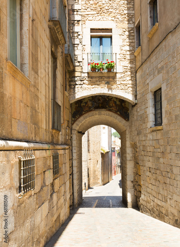 Arch over old narrow street of city. Girona