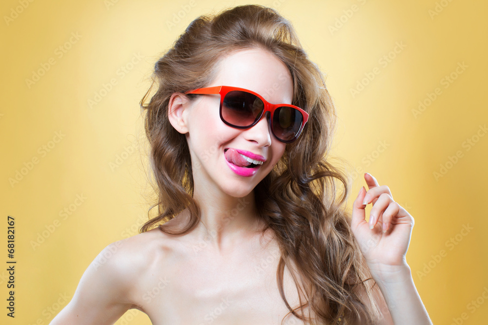 Girl with sunglasses showing her tongue, horizontally studio sho Girl with sunglasses showing her tongue, horizontally studio sho