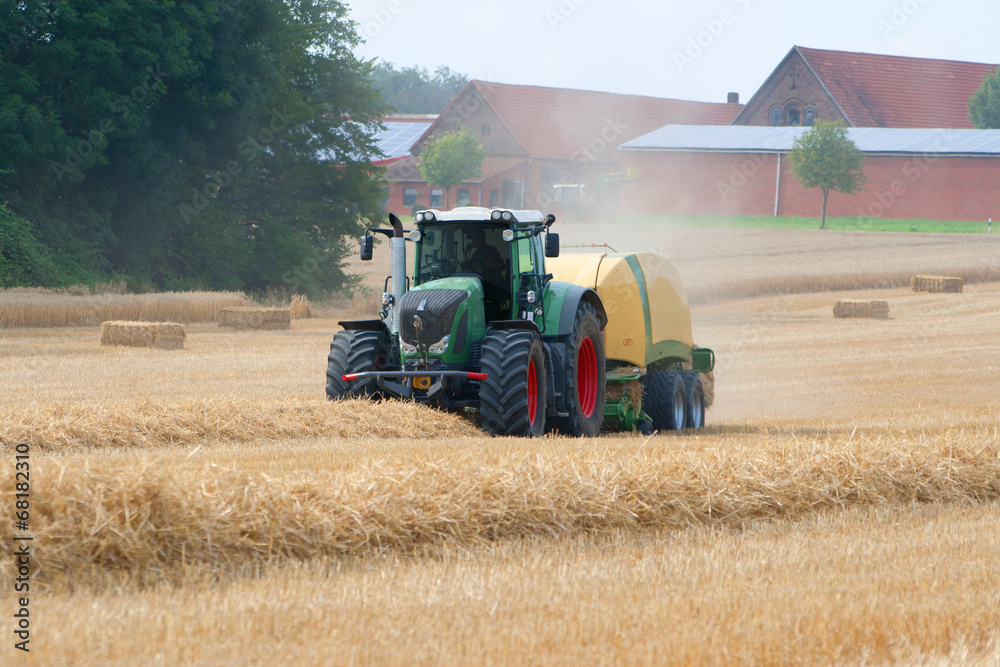 Traktor presst Strohballen