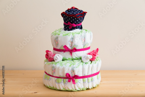 Fake layered cake made from diapers, babysocks, and a babydress photo