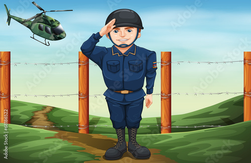 A soldier in front of the barbwire fence