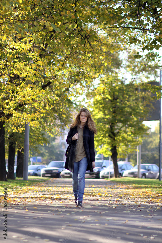 Beautiful young woman walking in autumn park Beautiful young woman walking in autumn park