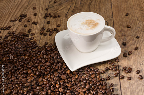 Tasse Cappuccino und Kaffeebohnen