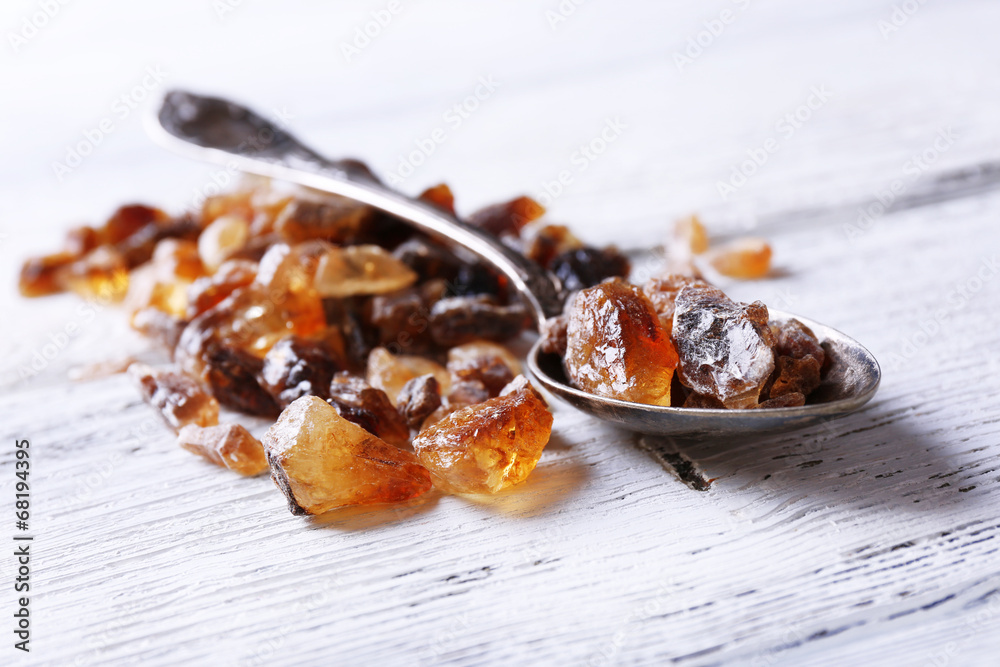 Reed sugar in spoon on wooden background Reed sugar in spoon on wooden background
