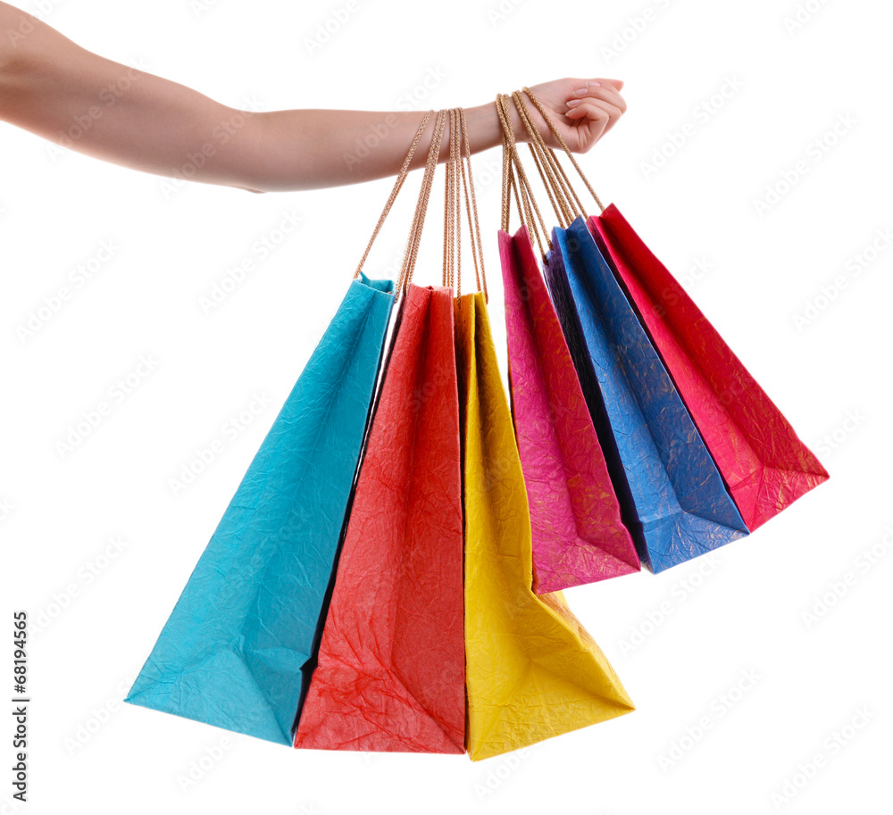 Female hand holding paper shopping bags isolated on white