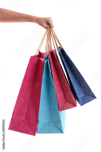 Female hand holding paper shopping bags isolated on white