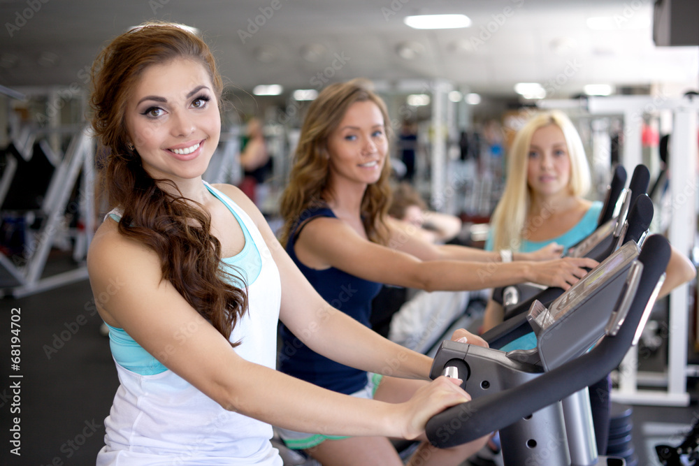 People training in a gym using exercise bicycles. People training in a gym using exercise bicycles.