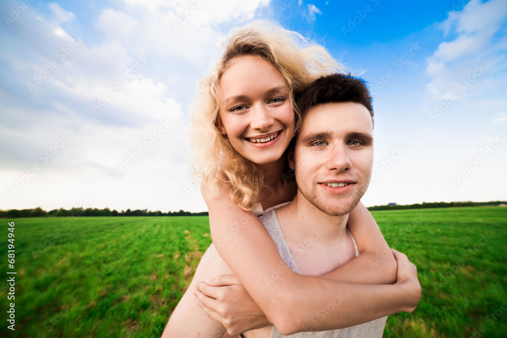 The couple smiles against a background sky The couple smiles against a background sky
